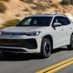 2026 Volkswagen Tiguan driving on a highway showcasing smooth performance and compact SUV handling
