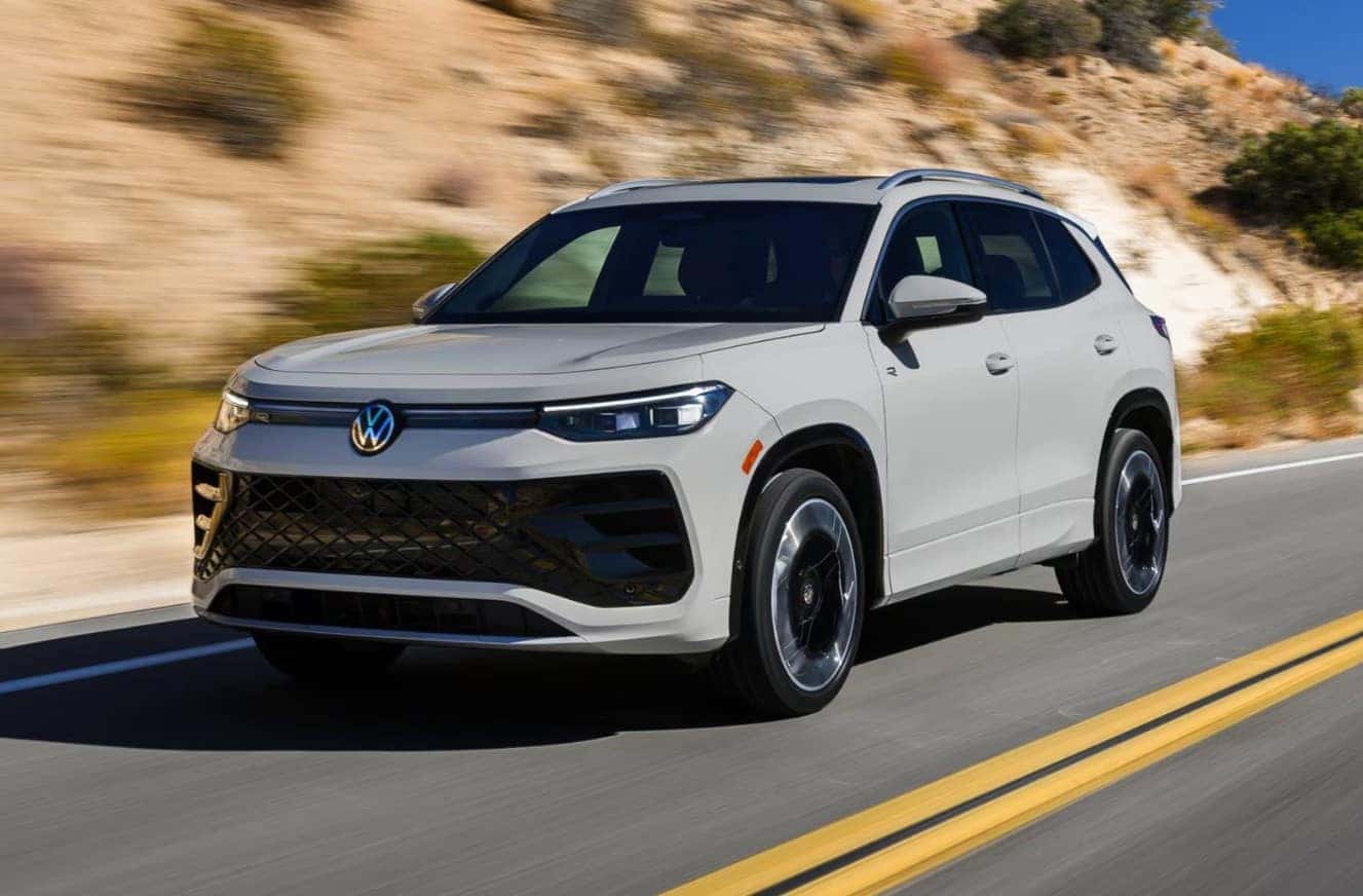 2026 Volkswagen Tiguan driving on a highway showcasing smooth performance and compact SUV handling