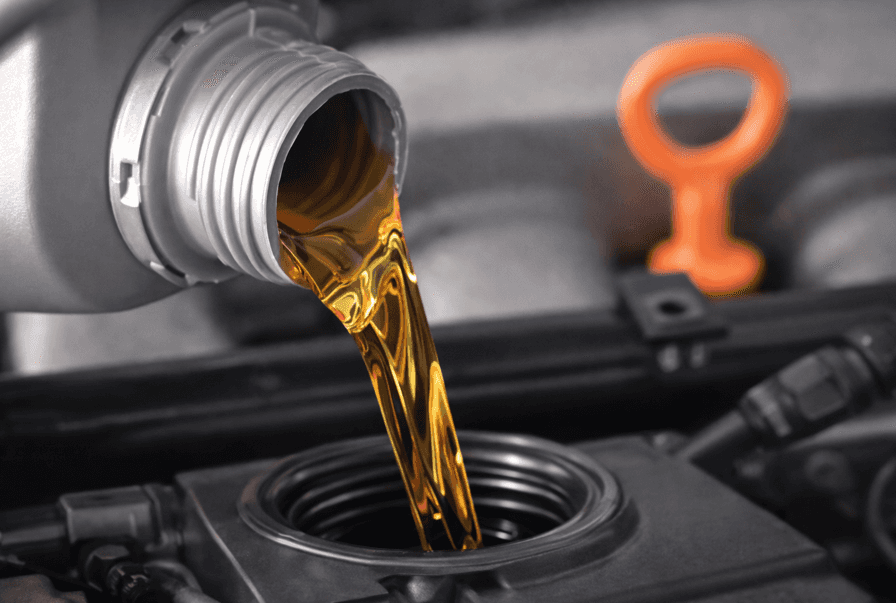 close-up of motor oil being poured into an engine showing clean oil flow during an oil change