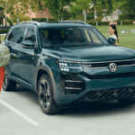 2027 Volkswagen Atlas in Sacramento Green parked beside a neighborhood park