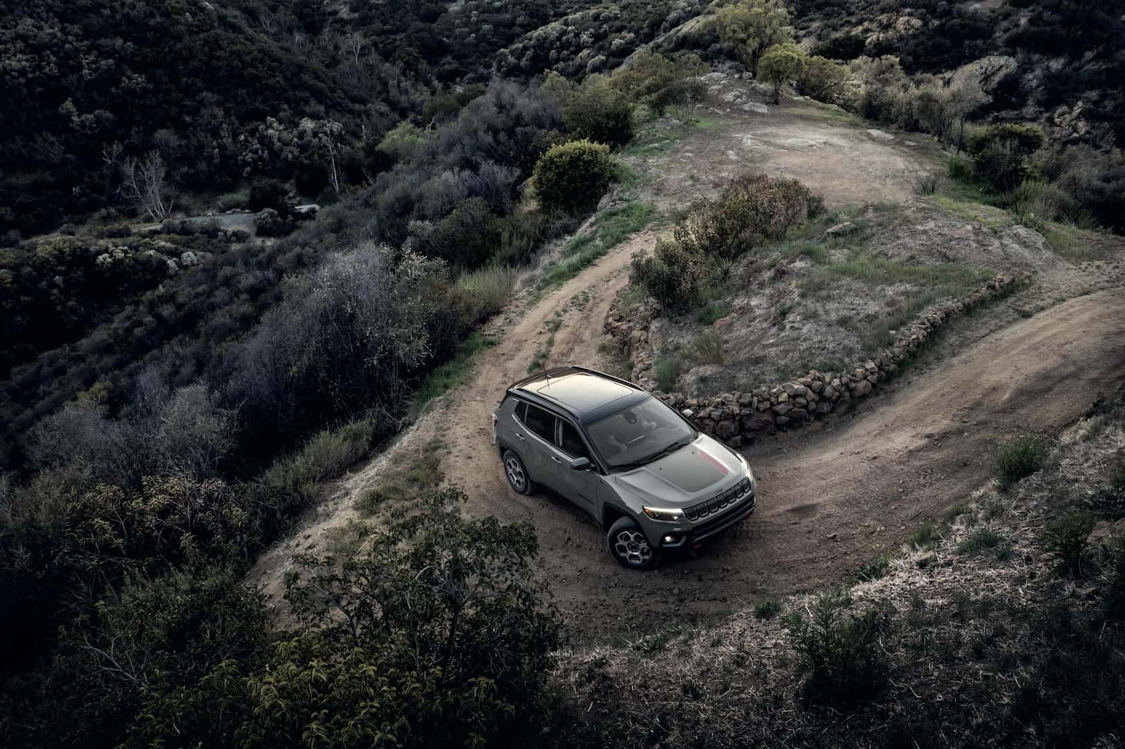 2022 Compass Trailhawk in Sting Gray driving up a dirt switchback road