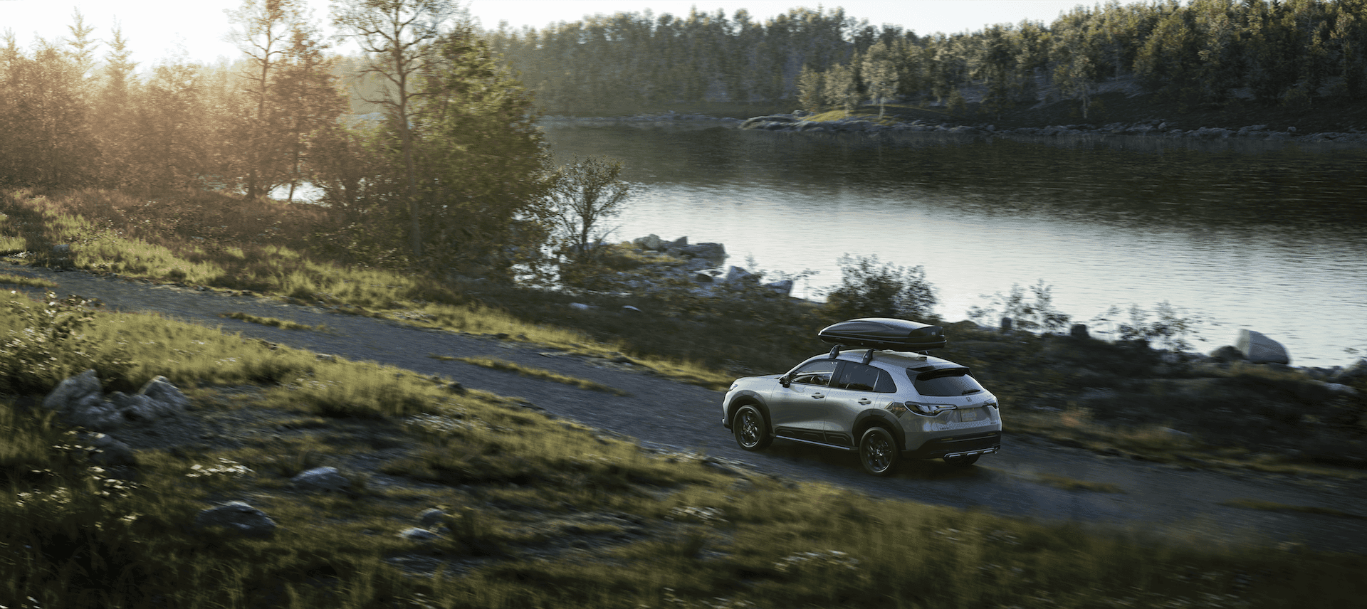 2023 Honda HR-V driving on gravel path in the forest alongside a river