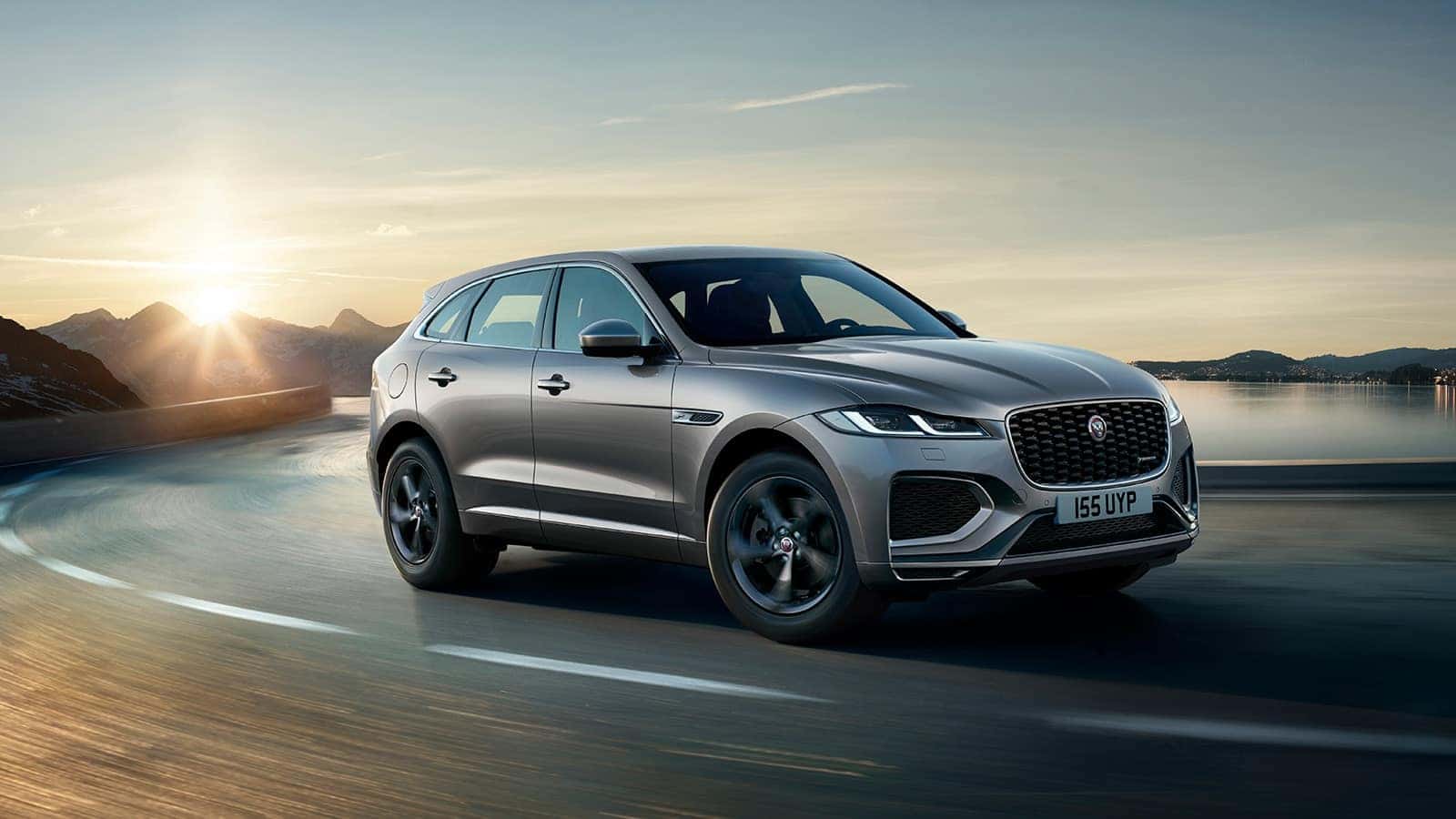 Jaguar F-Pace driving on the open road with a mountainous scenery in the background