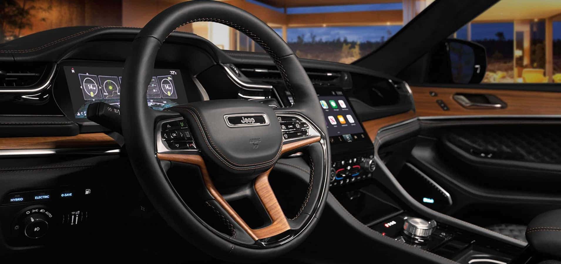 The interior of the 2023 Grand Cherokee featuring the wheel and dashboard with black and brown accent colors.