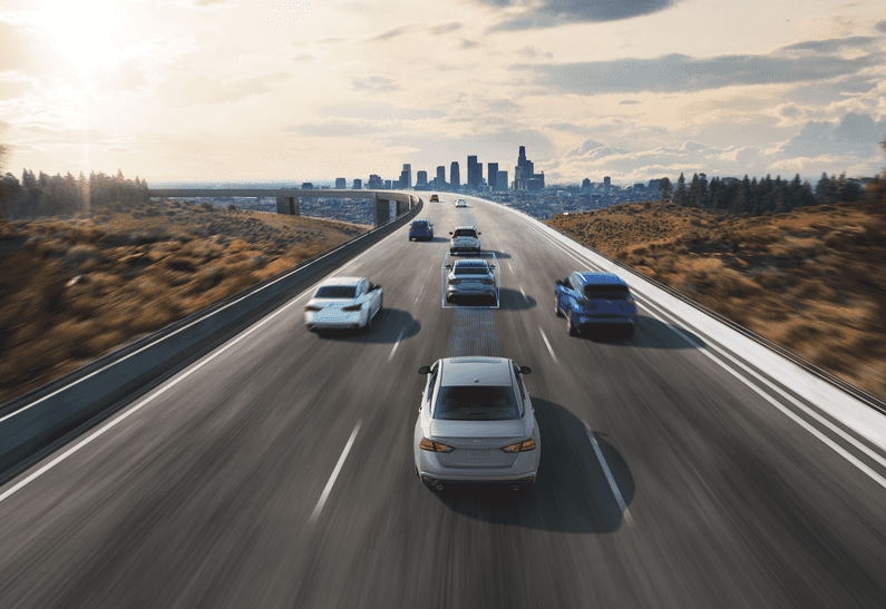 Multiple Altima's driving on a highway with a city skyscrape outline in background