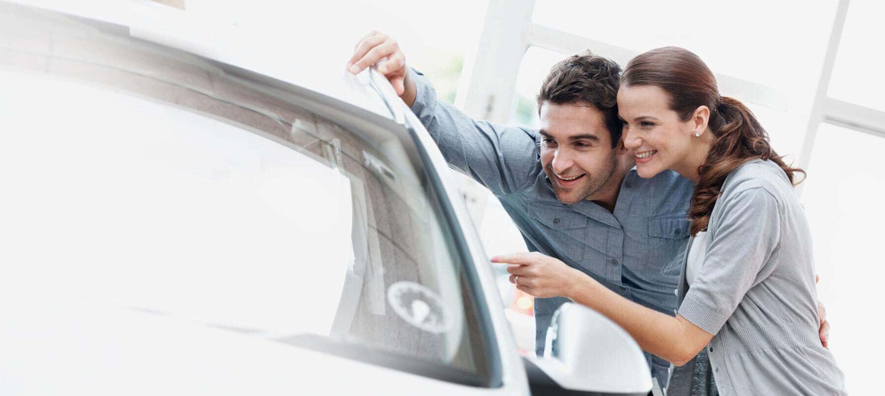 couple leaning over driver side of vehicle