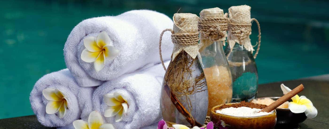 Spa towels and salts in front of a blue water background