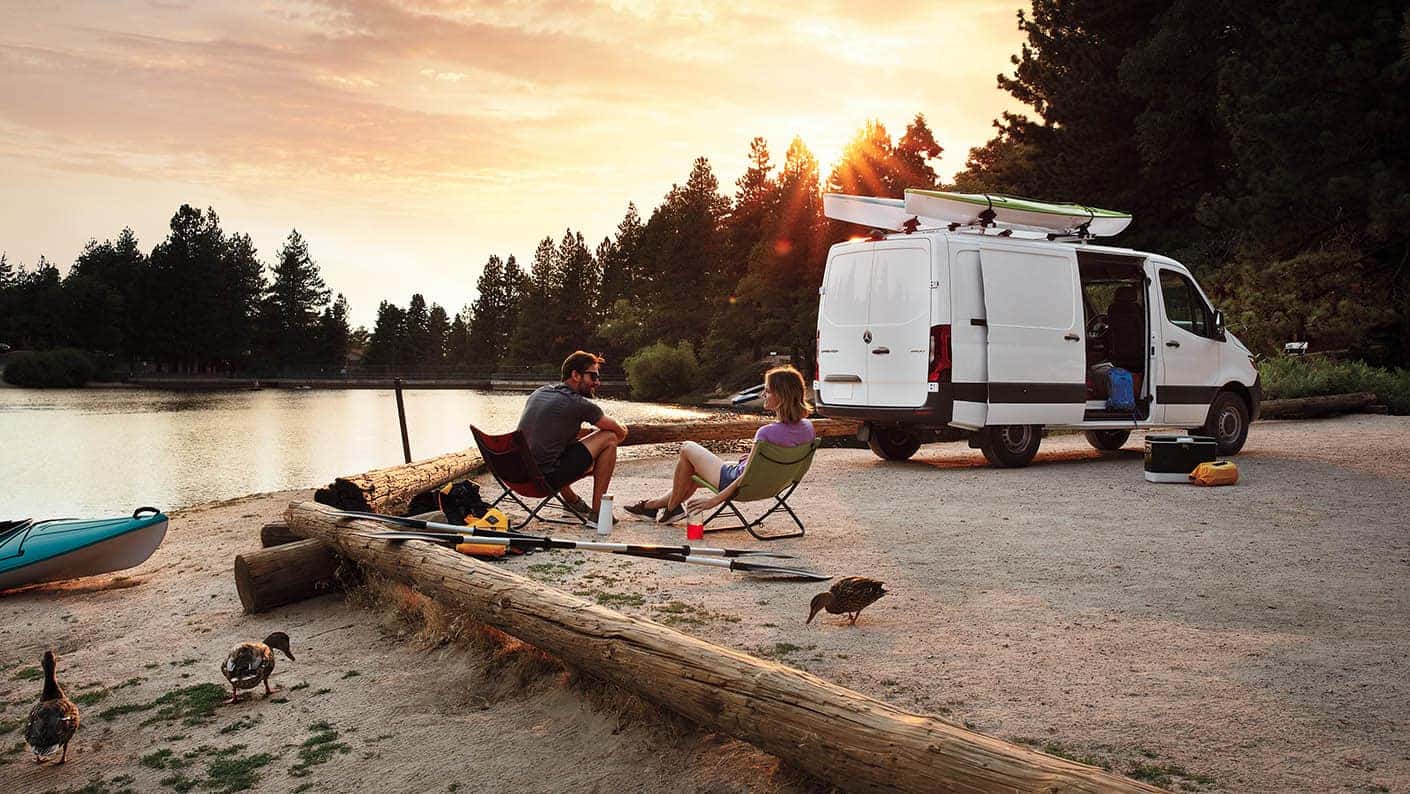 Mercedes-Benz Sprinter van parked at a lakeside campsite
