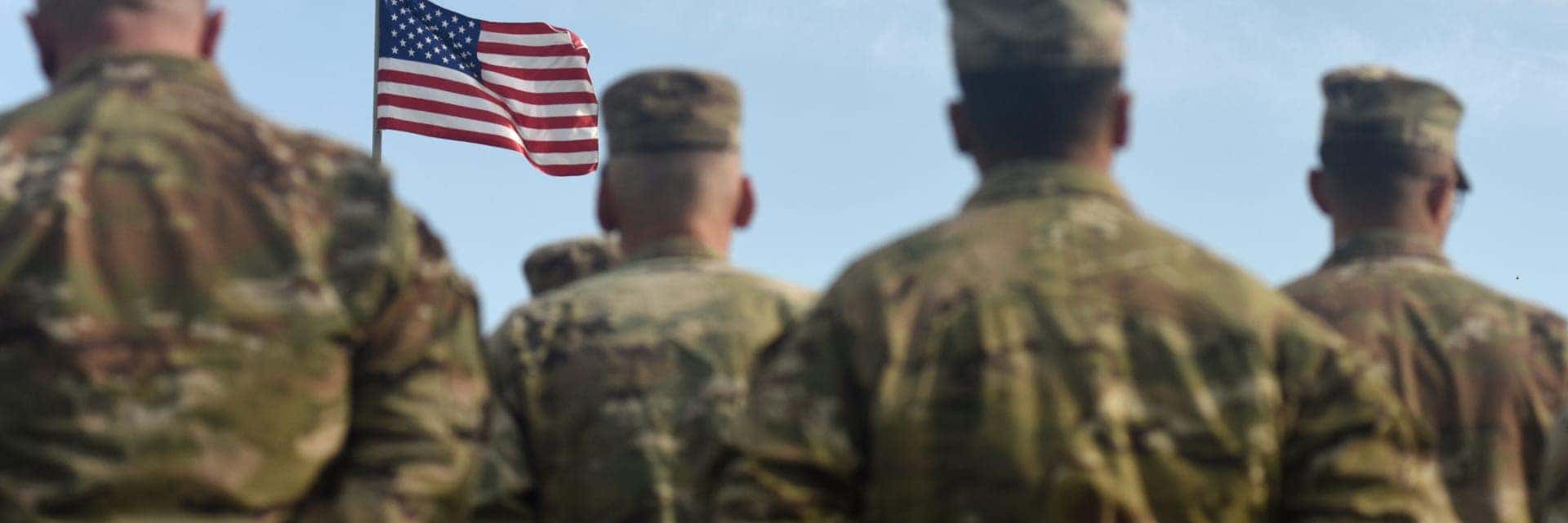 Military members looking at a flag
