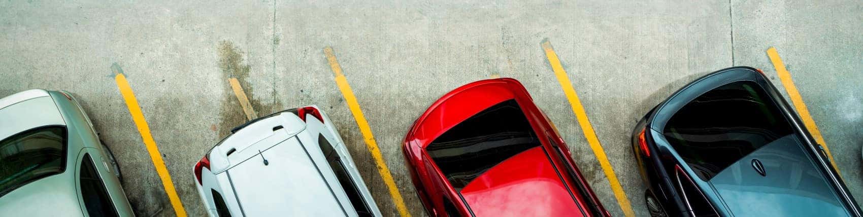 Cars parked in lot view of the rear bumpers