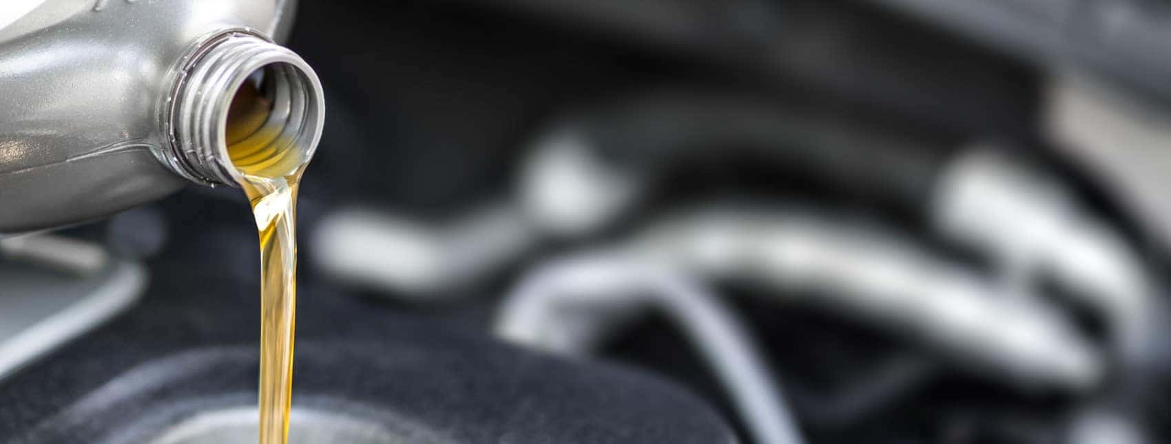 Close up of oil pouring from bottle blurry background