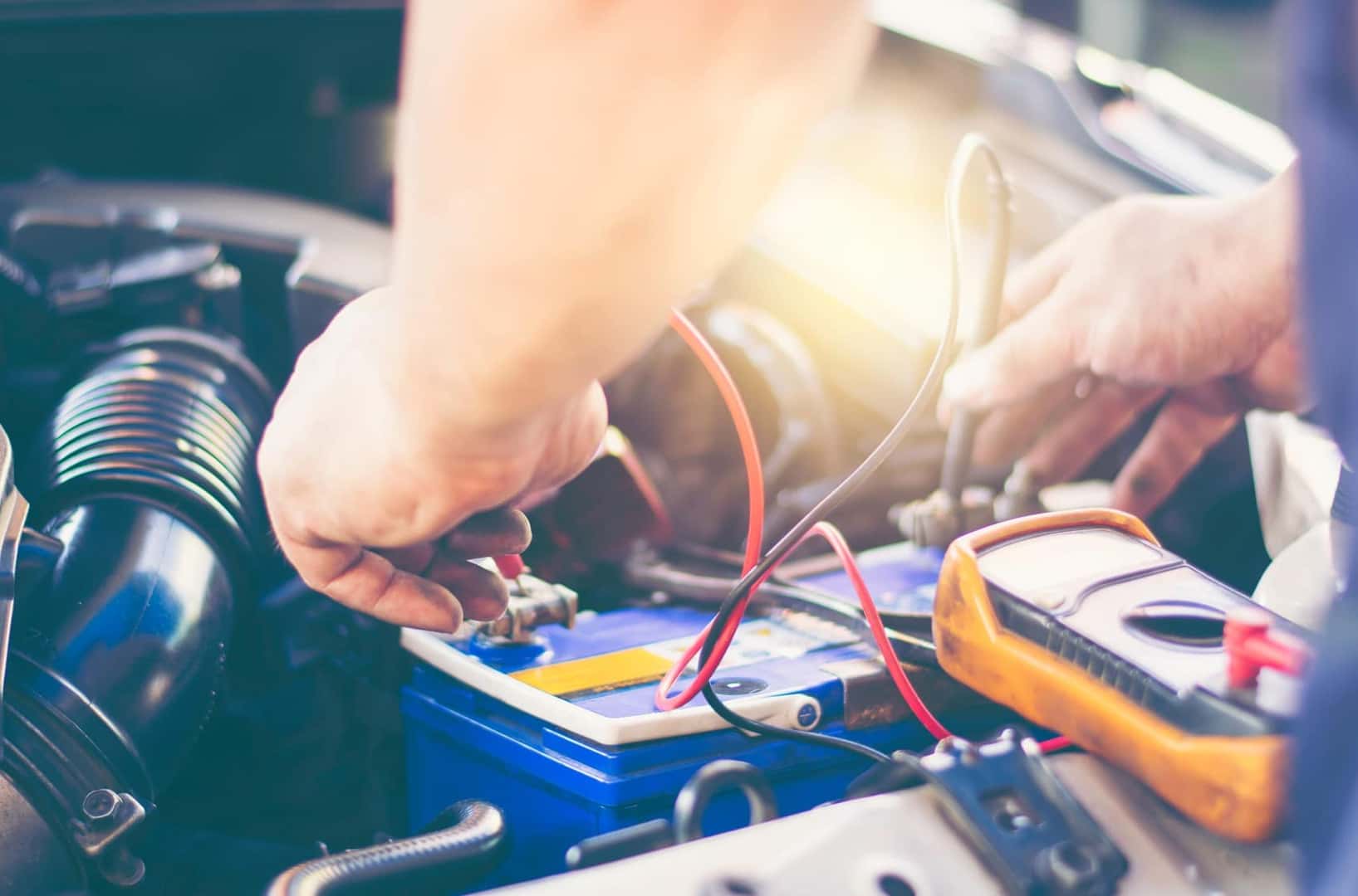 Vehicle technician running diagnostics on car battery