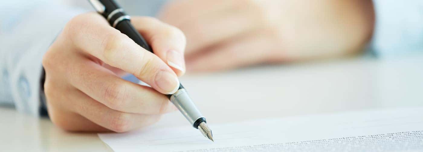 Mans Hand Reviewing a Car Financing Agreement