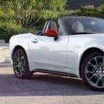 white FIAT Spider in driveway with trees in background