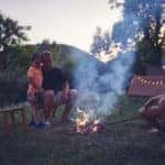 Father with children making a camping fire in the backyard.