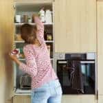 A woman cleaning out and organizing her pantry