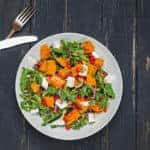 Salad with greens, sweet potato, and pomegranate seeds