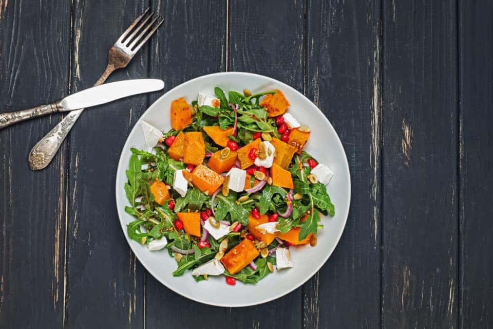 Salad with greens, sweet potato, and pomegranate seeds