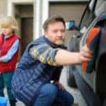 Dad and son washing car in the winter together
