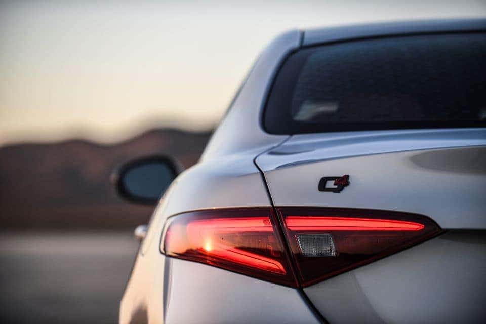 A closeup photo of a silver Alfa Romeo TI Sport the left rear tailight