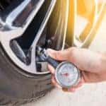 close up of hand checking tire pressure