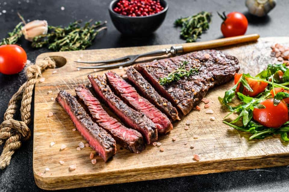 A photo taken from above of a London Broil, a sliced flank steak.
