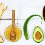 Ingredients for hair mask banana, honey, aloe and avocado on the white board, top view