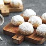cookies in powdered sugar on a wooden cutting board