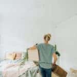 Photo of a young woman arranging the bedroom