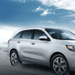 A white 2020 Kia Sorento driving on a mountain road.