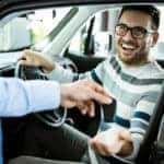 Car shopper taking the keys of the vehicle he purchased from a dealership