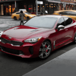 A red 2020 Kia Stinger on a city street.