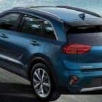 A Blue Kia Niro driving on a seaside highway