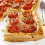 Tomato tart, puff pastry topped with mustard, cheese and cherry toamtoes.