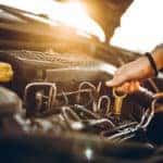 Woman checking car oil, close up.