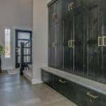 A mudroom hallway with grey cabinets