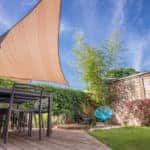 Modern house terrace in summer with table and shade sail