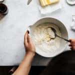 Directly above photograph of a person preparing pie dough.