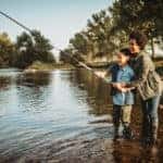 Mother teaching her son how to catch a fish