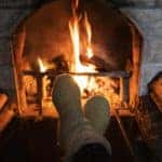 Foot in wool socks warming by the fireplace