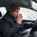 Driver heating his hand in his car so he can a little warm up himself