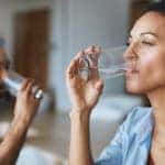 Shot of a couple drinking glasses of water together at home