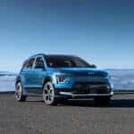 The 2025 KIA Niro PHEV parked in front of a scenic mountainscape, showcases modern design and innovative features.