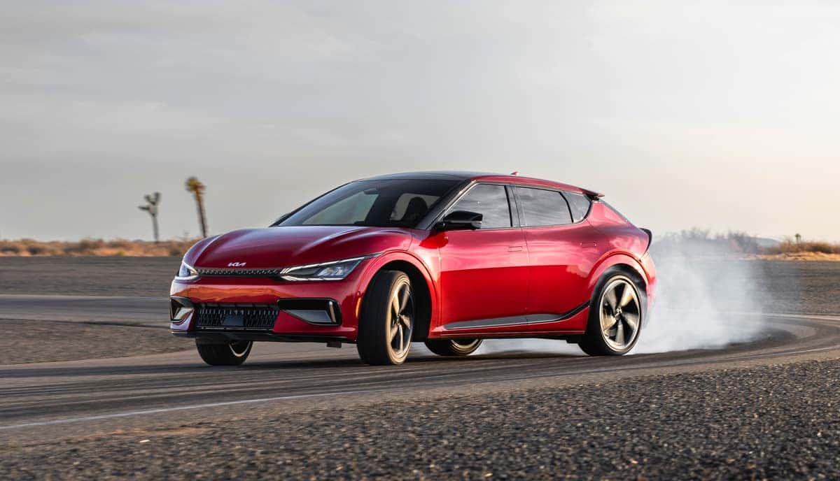 A red 2024 KIA EV6 drifting on a racetrack