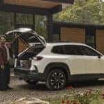 2026 Mazda CX-50 HEV parked in a driveway with a couple opening the trunk