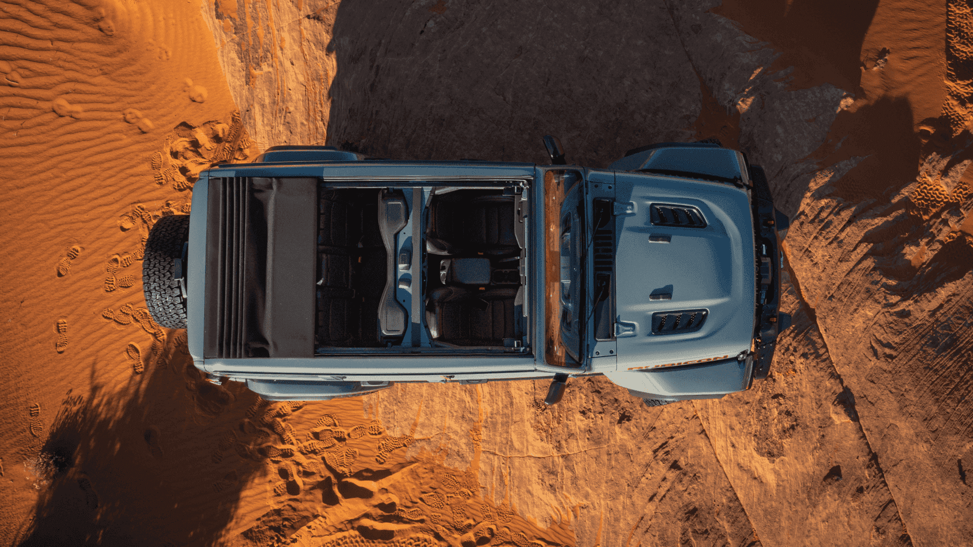 Overhead view of 2025 Jeep Wrangler Rubicon with open roof on desert terrain