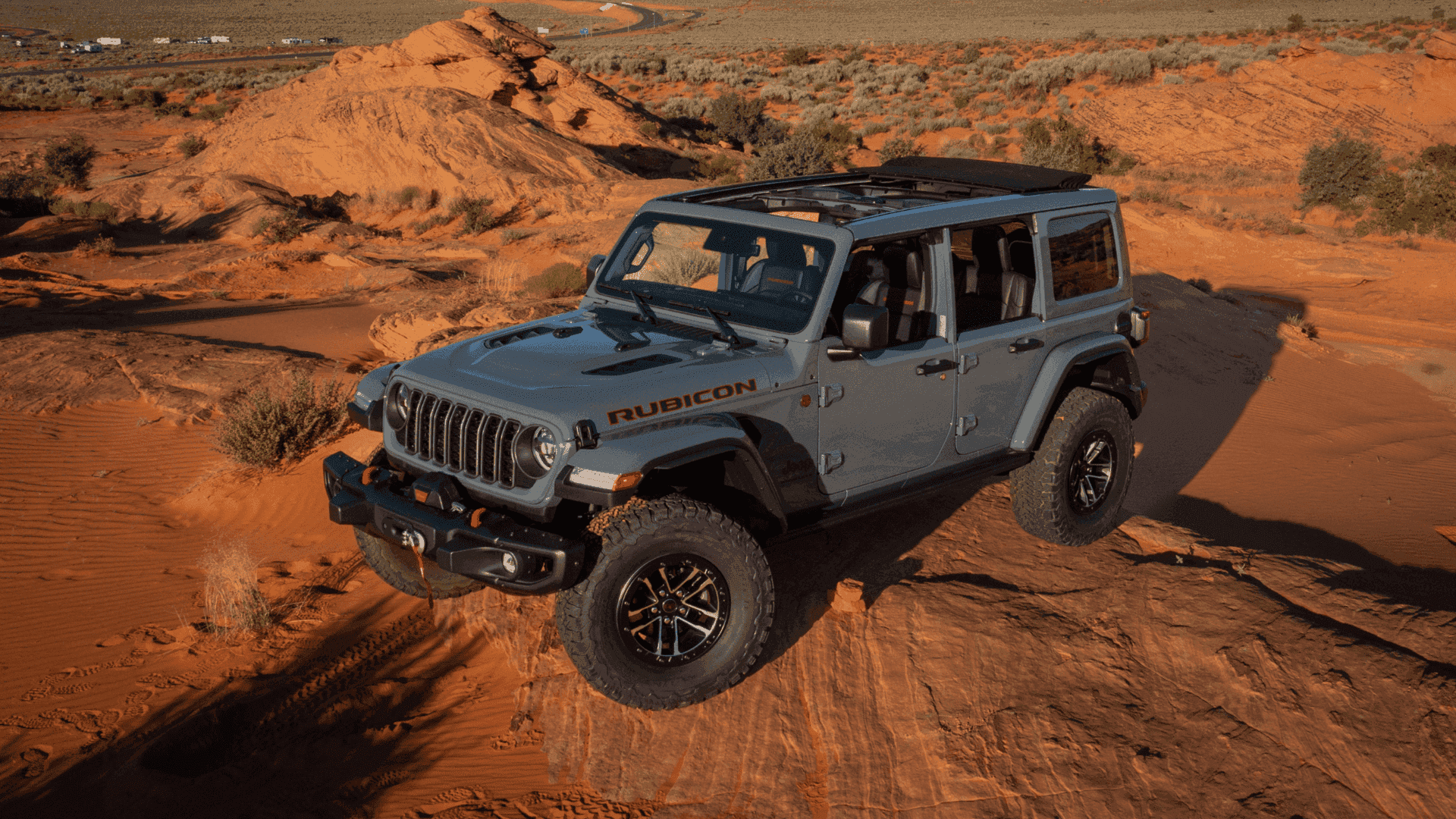 2025 Jeep Wrangler Rubicon climbing red rock terrain with roof panels removed