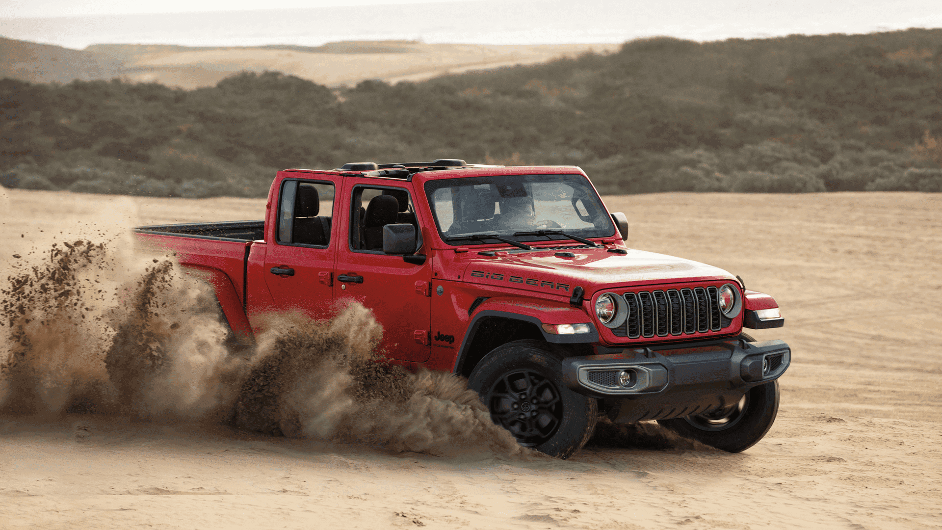Red 2025 Jeep® Gladiator Big Bear kicking up sand during off-road desert trail drive