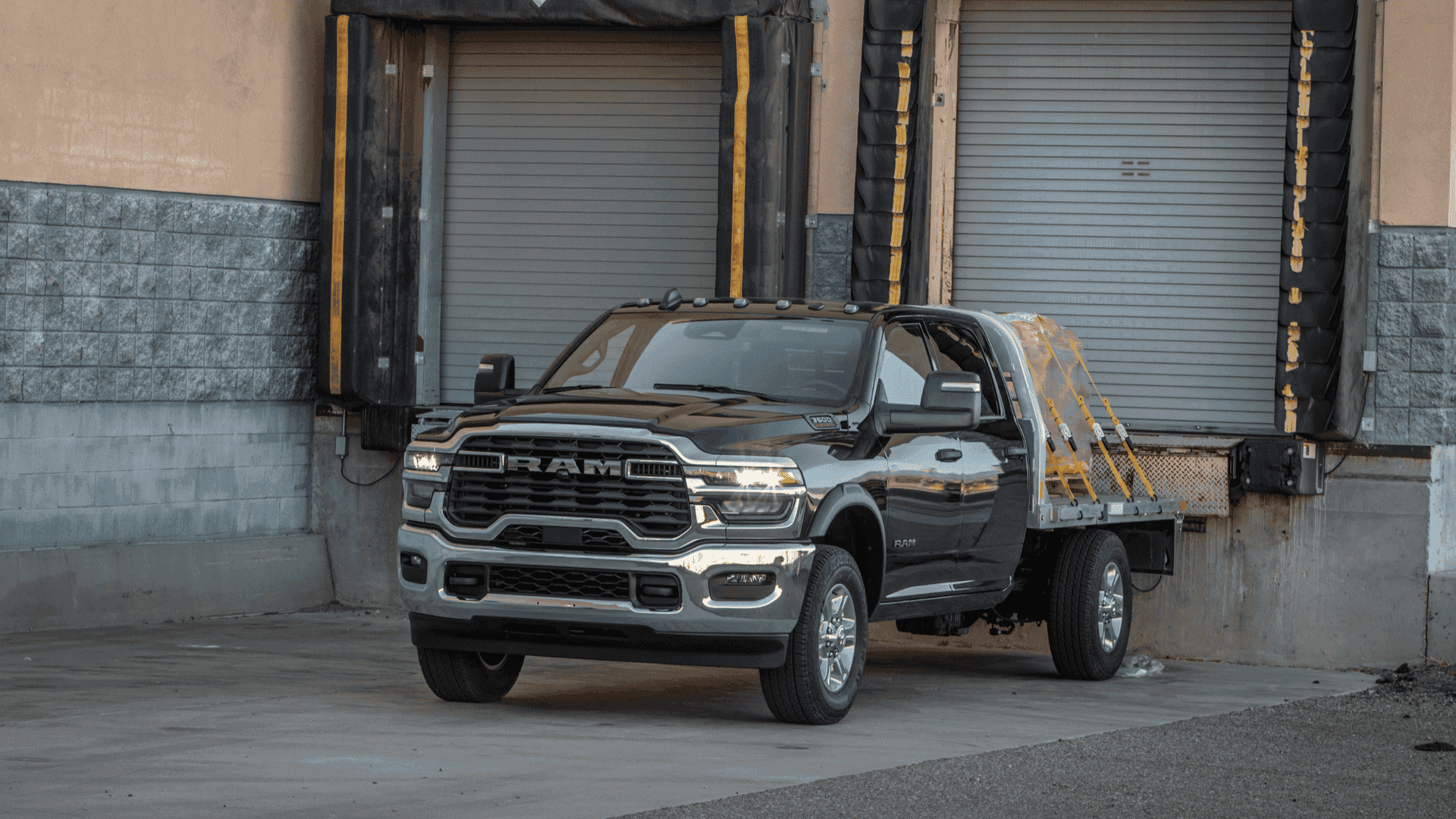2025 Ram 3500 with flatbed loaded at a warehouse dock, ready for heavy-duty commercial work