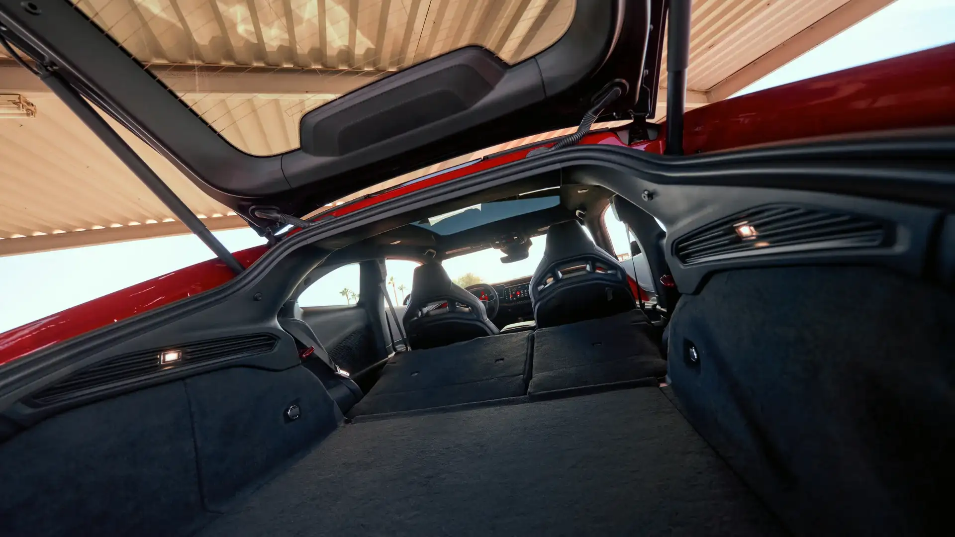 Cabin of 2026 Dodge Charger Daytona with red ambient lighting and sport-style digital instrument panel.